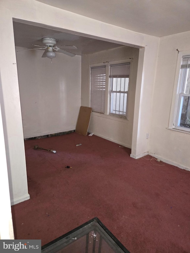 spare room with a healthy amount of sunlight, carpet, baseboards, and ceiling fan