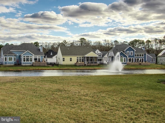 exterior space with a residential view, a water view, a yard, and fence