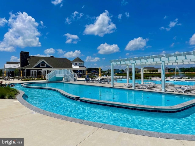 community pool with a patio area and a pergola