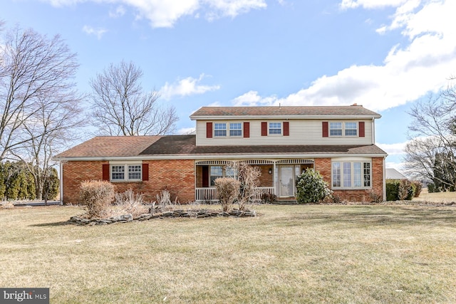 traditional-style home with a front yard and brick siding