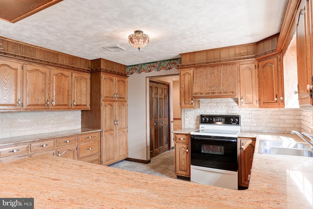 kitchen featuring range with electric stovetop, tasteful backsplash, light countertops, visible vents, and a sink