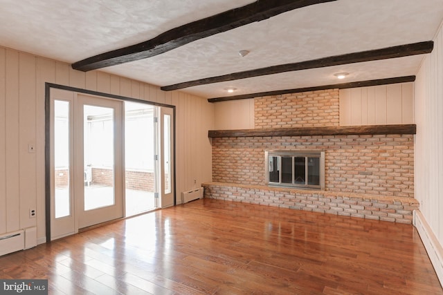 unfurnished living room with a baseboard radiator, beamed ceiling, a textured ceiling, and wood finished floors