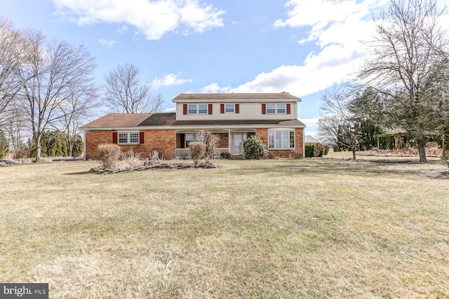 traditional-style house with brick siding and a front yard