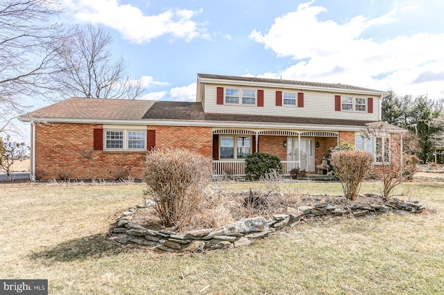 traditional home featuring a porch, brick siding, and a front lawn