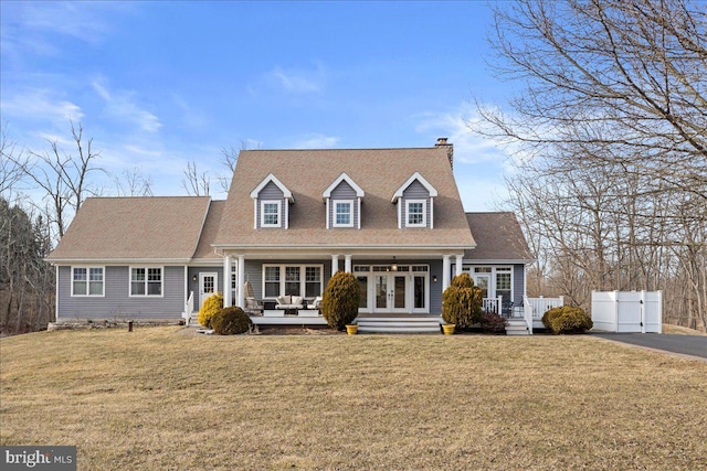 new england style home with a shingled roof, fence, a front lawn, and french doors