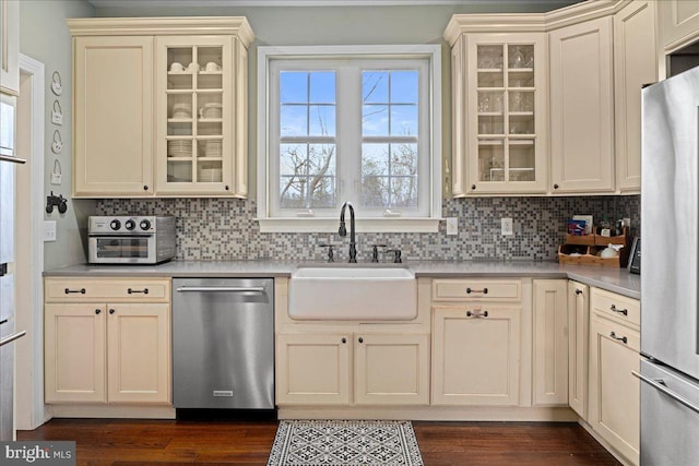 kitchen with dark wood finished floors, stainless steel appliances, a sink, and light countertops