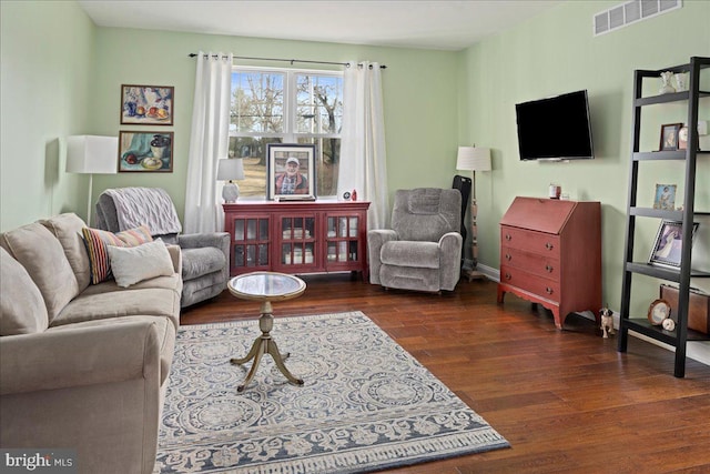 living area featuring wood finished floors, visible vents, and baseboards