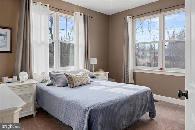 bedroom featuring dark colored carpet and baseboards