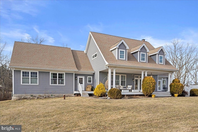 cape cod house featuring a porch, roof with shingles, and a front yard