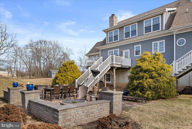 rear view of property featuring a chimney, stairway, and a patio area