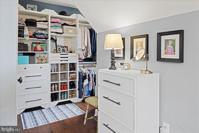 walk in closet with dark wood-style floors and lofted ceiling