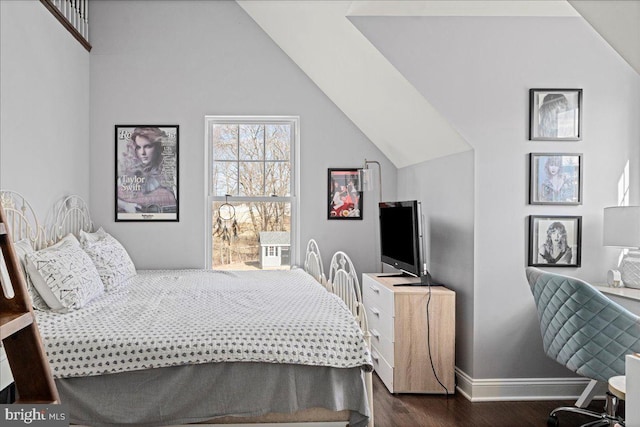 bedroom with vaulted ceiling, dark wood finished floors, and baseboards