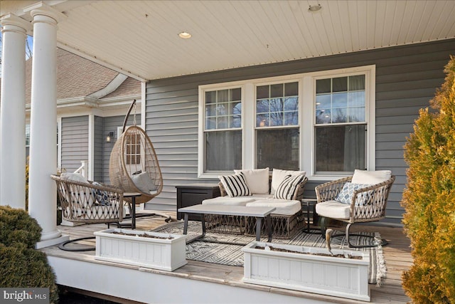 wooden deck with an outdoor hangout area and covered porch