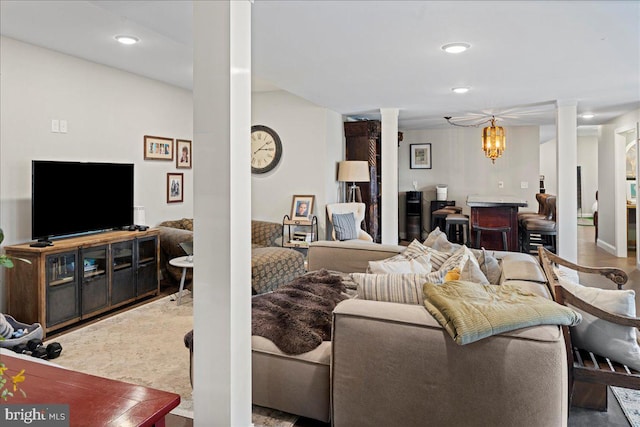 living room with recessed lighting, decorative columns, and a notable chandelier