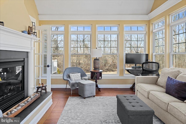 sunroom / solarium with a glass covered fireplace and vaulted ceiling