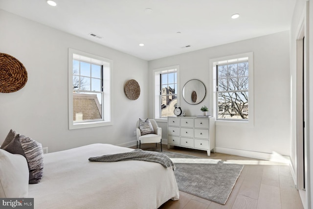 bedroom featuring baseboards, visible vents, wood finished floors, and recessed lighting