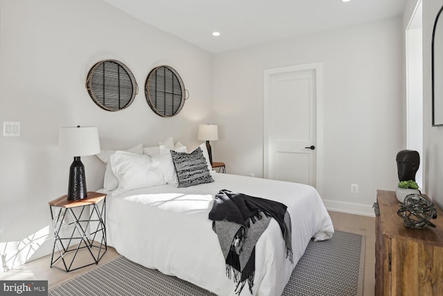 bedroom with recessed lighting, wood finished floors, and baseboards