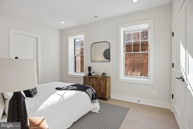 bedroom featuring light wood finished floors, visible vents, baseboards, and recessed lighting