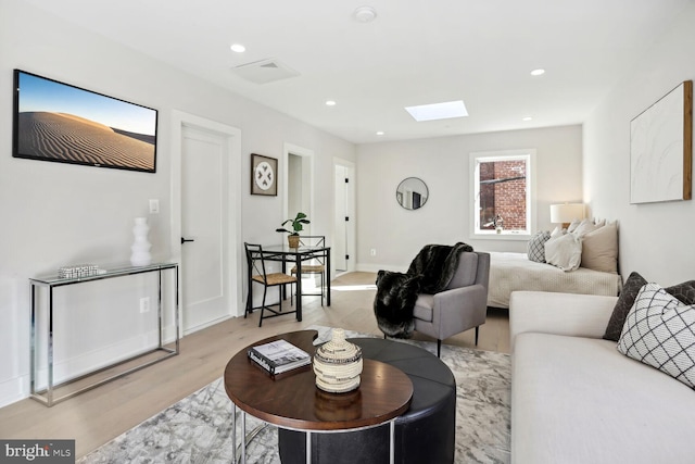 living room with a skylight, light wood-style flooring, baseboards, and recessed lighting