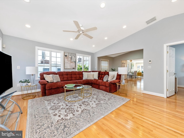 living area featuring vaulted ceiling, recessed lighting, visible vents, and light wood-type flooring