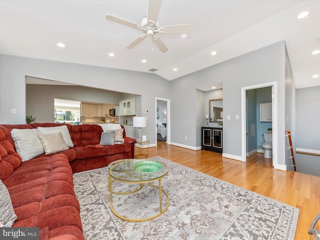 living room featuring lofted ceiling, recessed lighting, light wood finished floors, baseboards, and ceiling fan