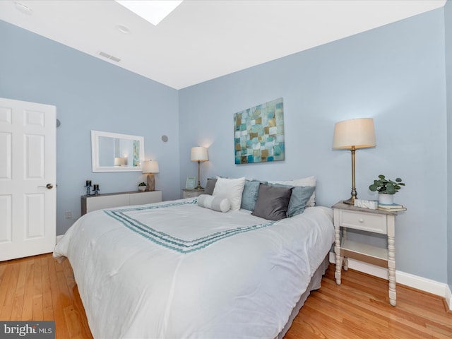 bedroom with baseboards, visible vents, a skylight, and light wood-style floors