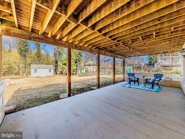 view of patio with an outdoor structure, outdoor dining space, and a shed