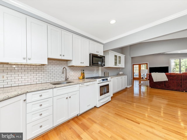 kitchen with white appliances, a sink, white cabinets, light wood-style floors, and crown molding