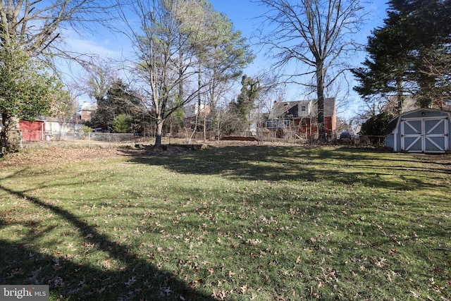 view of yard featuring a storage unit, an outdoor structure, and fence