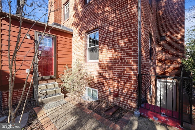 doorway to property featuring brick siding