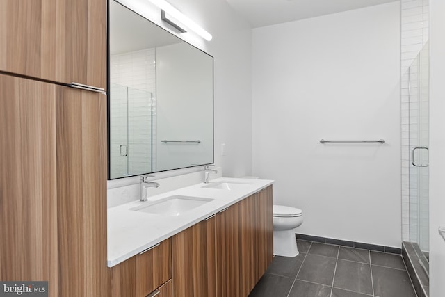 full bathroom featuring a stall shower, a sink, toilet, and tile patterned floors