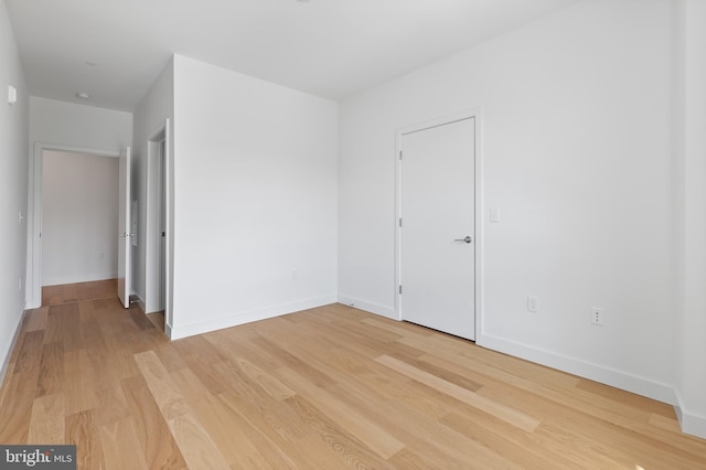 empty room with light wood-type flooring and baseboards