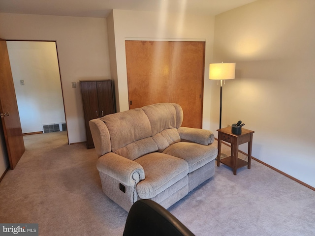 sitting room with visible vents, light carpet, and baseboards