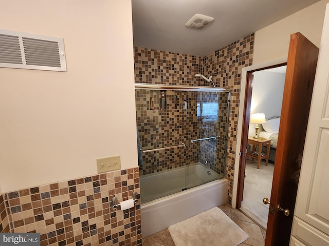 full bath featuring tile patterned flooring, enclosed tub / shower combo, visible vents, and tile walls