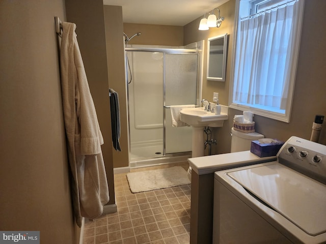 full bathroom with washer / dryer, a stall shower, and a sink