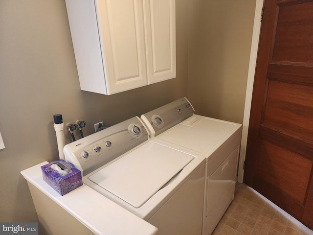 washroom featuring cabinet space and washer and clothes dryer