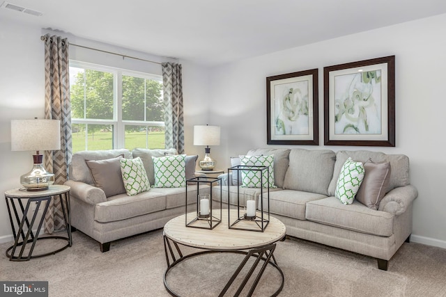 living area featuring baseboards, visible vents, and carpet flooring