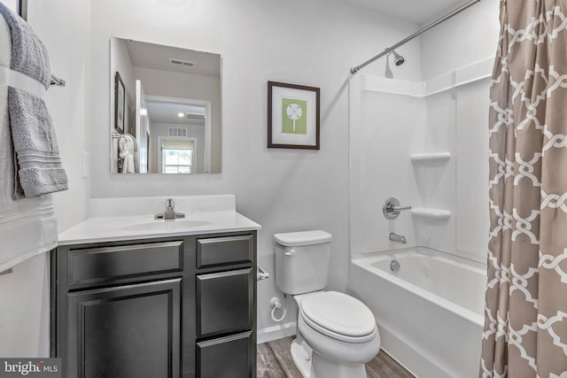 full bathroom featuring visible vents, toilet, shower / tub combo, vanity, and wood finished floors