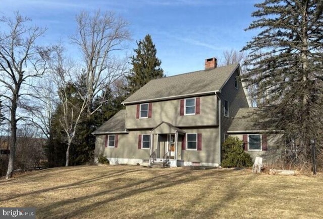 view of front of house with a chimney and a front lawn