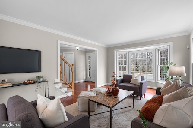 living area with stairs, crown molding, wood finished floors, and baseboards