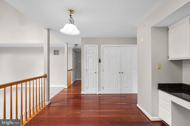 hallway featuring hardwood / wood-style flooring, baseboards, and visible vents