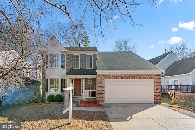 traditional-style house with brick siding, a shingled roof, a front yard, a garage, and driveway