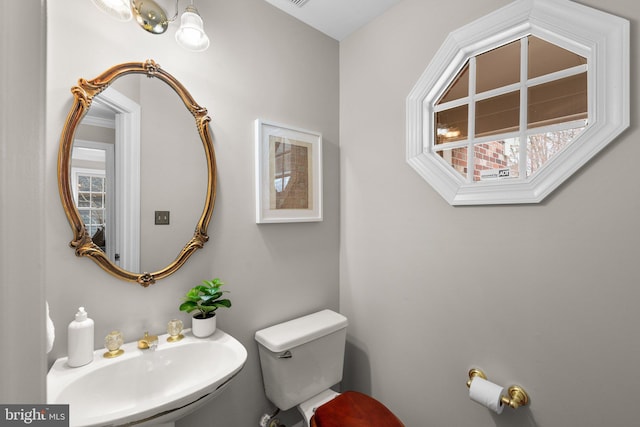 bathroom featuring a sink, plenty of natural light, and toilet