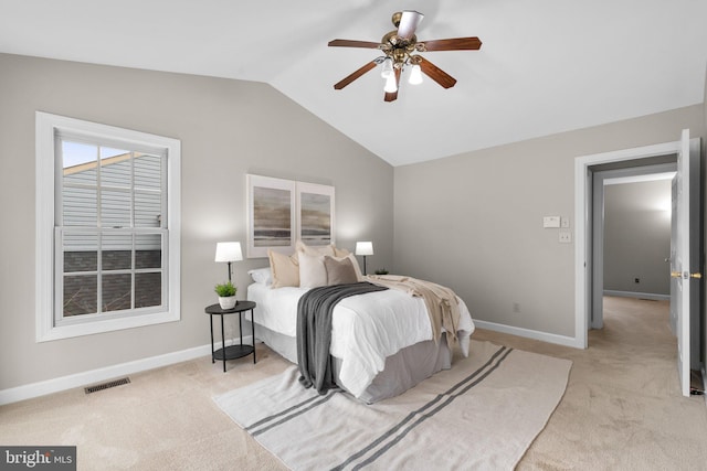 bedroom with baseboards, visible vents, lofted ceiling, and light carpet