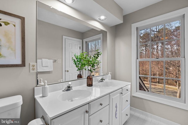 bathroom featuring a sink, toilet, and a wealth of natural light