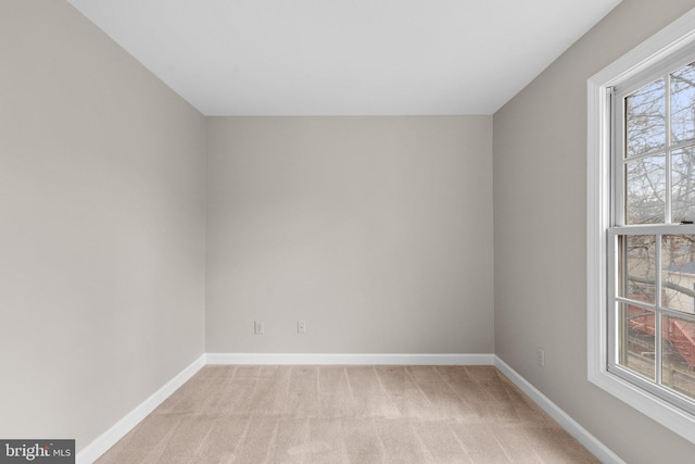 spare room with light colored carpet and baseboards