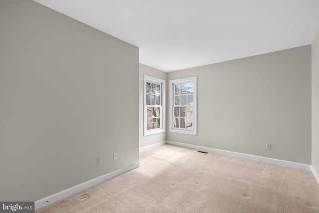 carpeted empty room featuring visible vents and baseboards