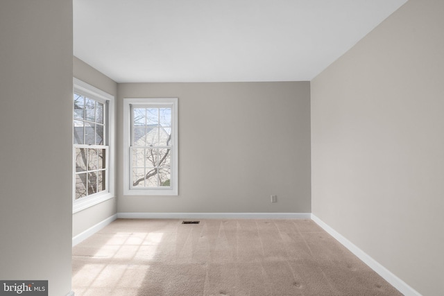 spare room featuring visible vents, baseboards, and carpet