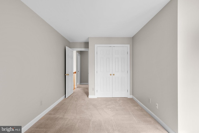 unfurnished bedroom featuring a closet, baseboards, and carpet floors