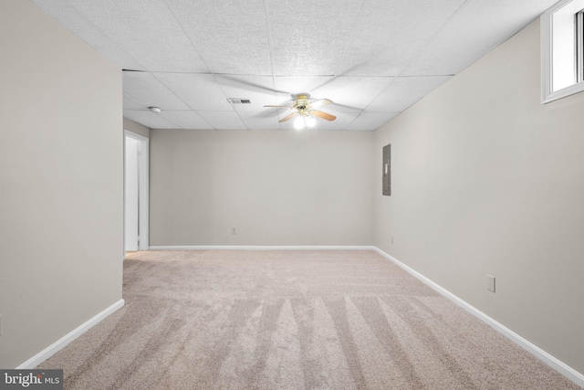 empty room featuring visible vents, a ceiling fan, electric panel, carpet floors, and baseboards